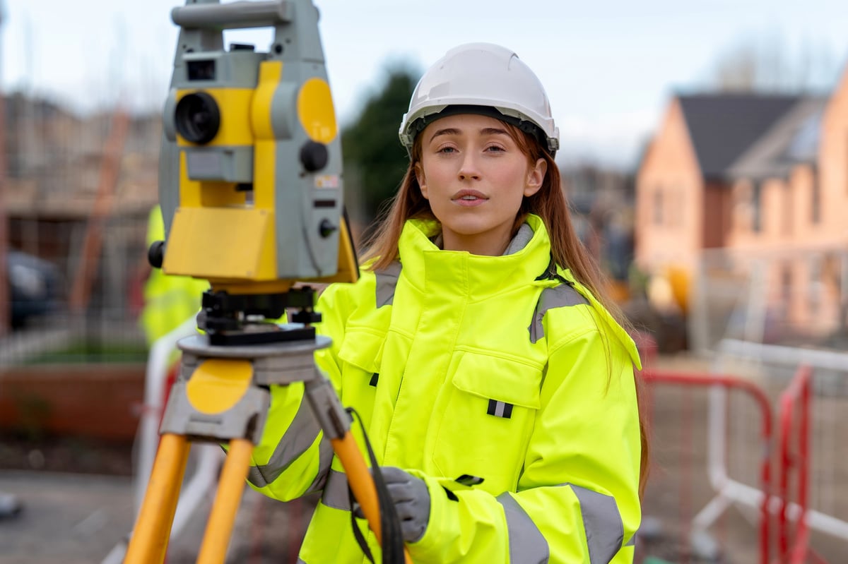 Professional property surveyor in Buckinghamshire using total station surveying equipment on a residential development site for accurate measurements